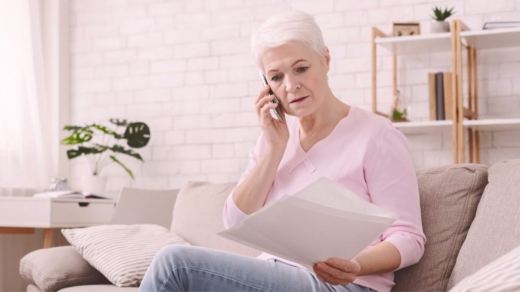 Middle aged woman on telephone indicating tax season scams done through vishing or voice phishing.