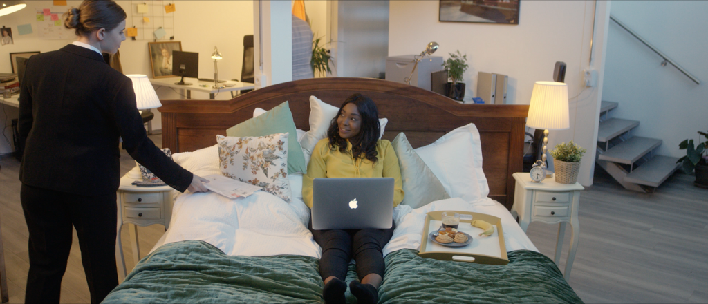 Woman doing hybrid work and cybersecurity from her bed while simultaneously at the office.